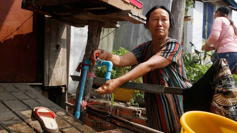 A woman running her water tap in Phnom Penh’s Tuol Kork district in February last year. Heng Chivoan Content image - Phnom Penh Post