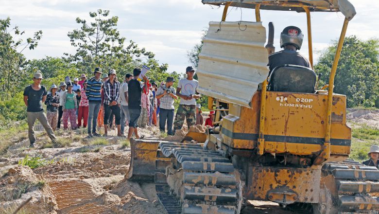 A group of villagers stand in front of a bulldozer to stop it from clearing community land in Kampong Chhnang province last year during a dispute with KDC International. Heng Chivoan Content image - Phnom Penh Post